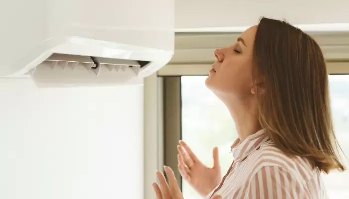 Woman Hot In Front Or Ductless Air Conditioner Unit